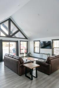 a living room with two leather couches and a table at The Sundance Cabin in Valemount