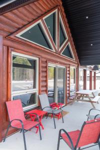 porche cubierto con sillas y chimenea en The Sundance Cabin, en Valemount