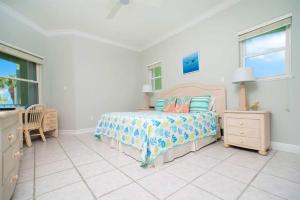 a bedroom with a bed and a dresser and windows at On The Bay in North Side