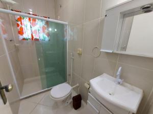 uma casa de banho com um chuveiro, um WC e um lavatório. em Nacif&Alcantara Suítes em Tamoios