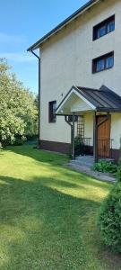 ein Haus mit einer Veranda und einem großen Rasenplatz in der Unterkunft Toprak Apartment 