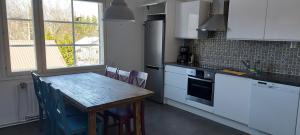 kuchnia z drewnianym stołem i białymi szafkami w obiekcie Toprak Apartment 