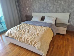 duże łóżko w sypialni z drewnianą podłogą w obiekcie San Stefano Plaza w Aleksandrii