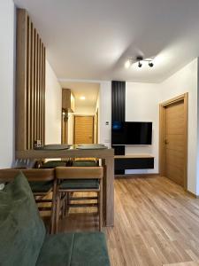 a dining room and living room with a table and chairs at Sofija Apartman Zlatibor in Zlatibor