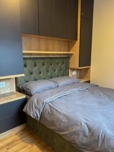 a bedroom with a large bed with a headboard at Sofija Apartman Zlatibor in Zlatibor