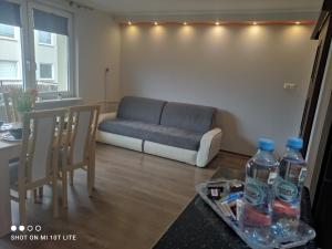 a living room with a couch and two chairs and water bottles at Apartament u Sylvie in Siedlce