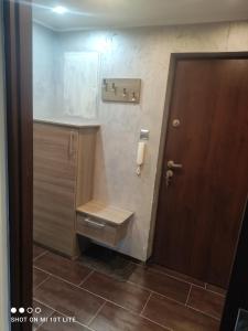 a bathroom with a toilet and a wooden door at Apartament u Sylvie in Siedlce
