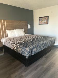 un letto grande in una stanza con pavimento in legno di Econo Lodge Calhoun South a Calhoun