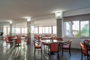 タオルミーナにあるホテル コラーロのダイニングルーム(テーブル、椅子、窓付)