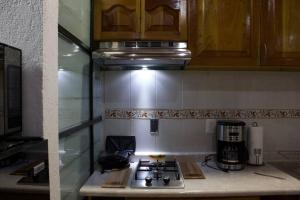 a kitchen with a stove top and a microwave at NIce & cozy apt in San José Ins. in Mexico City