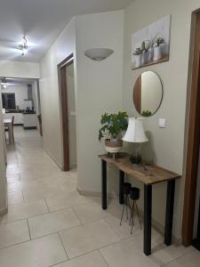 克拉倫代克的住宿－Bon Bida 1，走廊上设有一张桌子、一盏灯和一面镜子