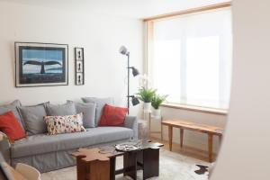 uma sala de estar com um sofá cinzento e uma mesa em FLH Santos Family Spacious Flat em Lisboa