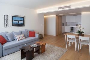 uma sala de estar com um sofá azul e uma mesa em FLH Santos Family Spacious Flat em Lisboa