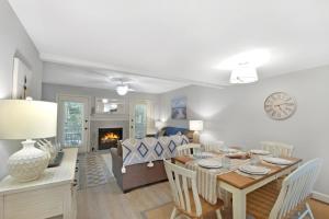 a dining room and living room with a table and a fireplace at Coral Cottage in Saint Simons Island