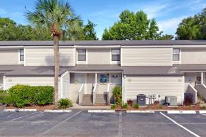 a building with a palm tree in front of it at Coral Cottage in Saint Simons Island