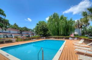 a large swimming pool with chairs at Coral Cottage in Saint Simons Island