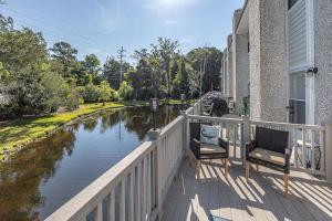 a balcony with two chairs next to a river at Selah in Saint Simons Island