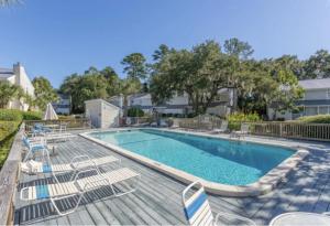 uma piscina com espreguiçadeiras e um visor de piscina em Selah em Saint Simons Island