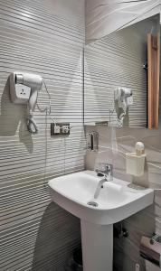 een badkamer met een witte wastafel en een spiegel bij Aparthotel Dar Nowara Chaouen in Chefchaouene