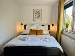 ein großes weißes Bett mit zwei Kissen darauf in der Unterkunft Design Apartment, Küche, Smart-TV, WLAN in Essen