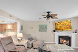 a living room with a ceiling fan and a fireplace at Harbour Oaks 311 in Saint Simons Island
