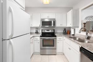 een witte keuken met een fornuis en een magnetron bij Harbour Oaks 418 in Saint Simons Island