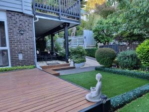 a garden with a wooden deck with a statue at Entire ground floor with full-privacy and family-friendly popular to ferry catchers in Wellington