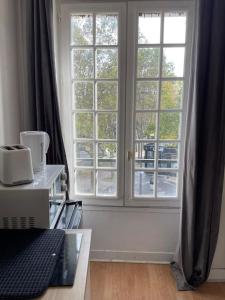Zimmer mit einem Fenster und einem Laptop auf einem Tisch in der Unterkunft Studio Paris 14 in Paris