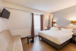a hotel room with a bed and a chair at Best Western Hotel & SPA Pau Lescar Aeroport in Lescar