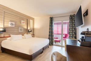 a hotel room with a large bed and a kitchen at Best Western Hotel & SPA Pau Lescar Aeroport in Lescar