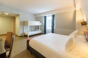 a bedroom with a bed and a desk and a chair at Best Western Hotel & SPA Pau Lescar Aeroport in Lescar