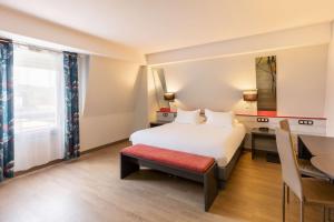 a hotel room with a bed and a desk at Best Western Hotel & SPA Pau Lescar Aeroport in Lescar
