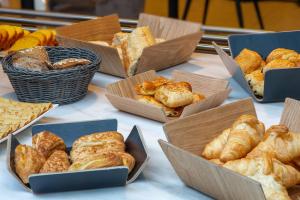 a bunch of different types of breads and pastries on a table at Best Western Hotel & SPA Pau Lescar Aeroport in Lescar