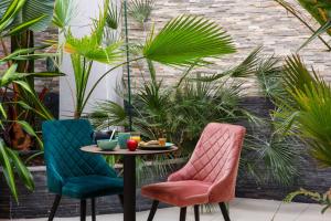 two chairs and a table in a courtyard at Best Western Hotel & SPA Pau Lescar Aeroport in Lescar