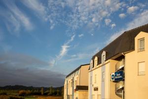 a building with a sign on the side of it at Best Western Hotel & SPA Pau Lescar Aeroport in Lescar