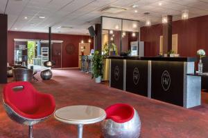 a lobby with a red chair and a table at Best Western Hotel & SPA Pau Lescar Aeroport in Lescar