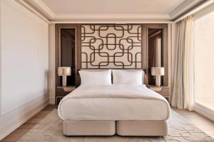 a bedroom with a large bed and two lamps at Nobu Hotel San Sebastián in Donostia-San Sebastián