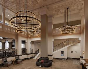 a lobby with two large chandeliers and chairs at Hotel Flor Tampa Downtown, Tapestry Collection By Hilton in Tampa