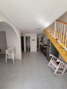 sala de estar con escalera y cocina en Casa Amarilla, en Zihuatanejo