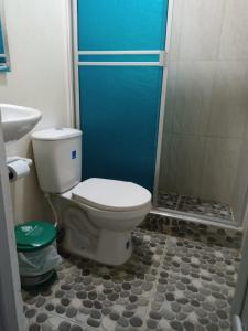 a bathroom with a toilet and a shower at Hotel Las Palmas de Puente Nacional in Puente Nacional
