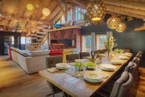 a dining room with a long wooden table and chairs at Chalet 1703 - OVO Network in Le Petit-Bornand-lès-Glières