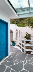 uma porta de garagem azul ao lado de uma casa em Zenith em Arraial do Cabo