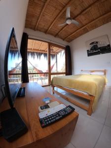 a bedroom with a bed and a desk with a computer at Lobitos Eco Lodge in Lobitos