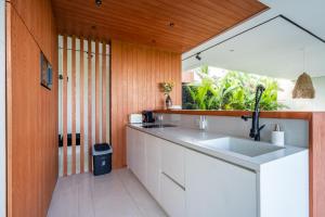 a kitchen with a white sink and wooden walls at GREEN FLOW Villas Ubud I in Ubud