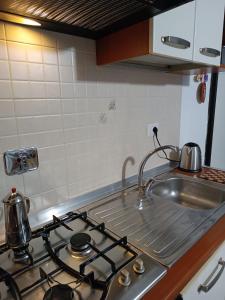 a kitchen stove top with a tea kettle on it at ARMAREAOVERSEASSUITES in Fiumicino