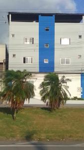 a building with two palm trees in front of it at Hostel Diniz II in Serra