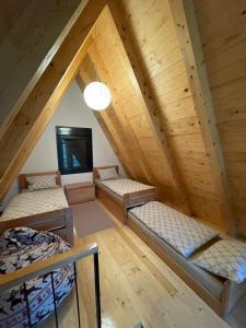 an attic room with four beds and a television at KoCHALET Apartment in Crni Vrh