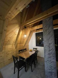 a wooden dining room with a table and chairs at KoCHALET Apartment in Crni Vrh