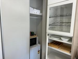 a kitchen with a white refrigerator and a microwave at Luxury Golf Stay and Play in Peregian Springs