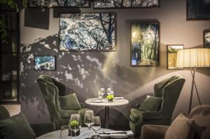 um restaurante com mesa e cadeiras e pinturas na parede em Adriatic Hotel by Maistra Collection em Rovinj